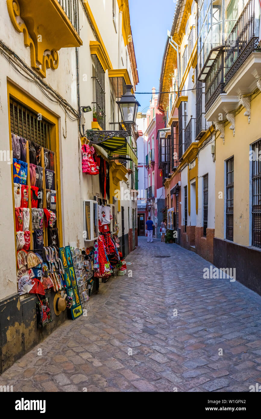 Shops on narrow street in the Barrio de Santa Cruz or old Jewish Quarter of Seville Spain Stock Photo