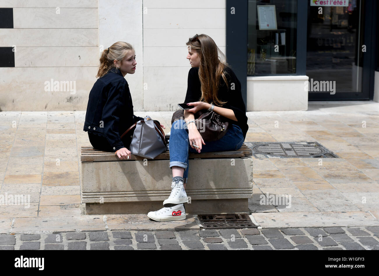 Two young women smoking cigarettes in Troyes, France, Europe Stock Photo