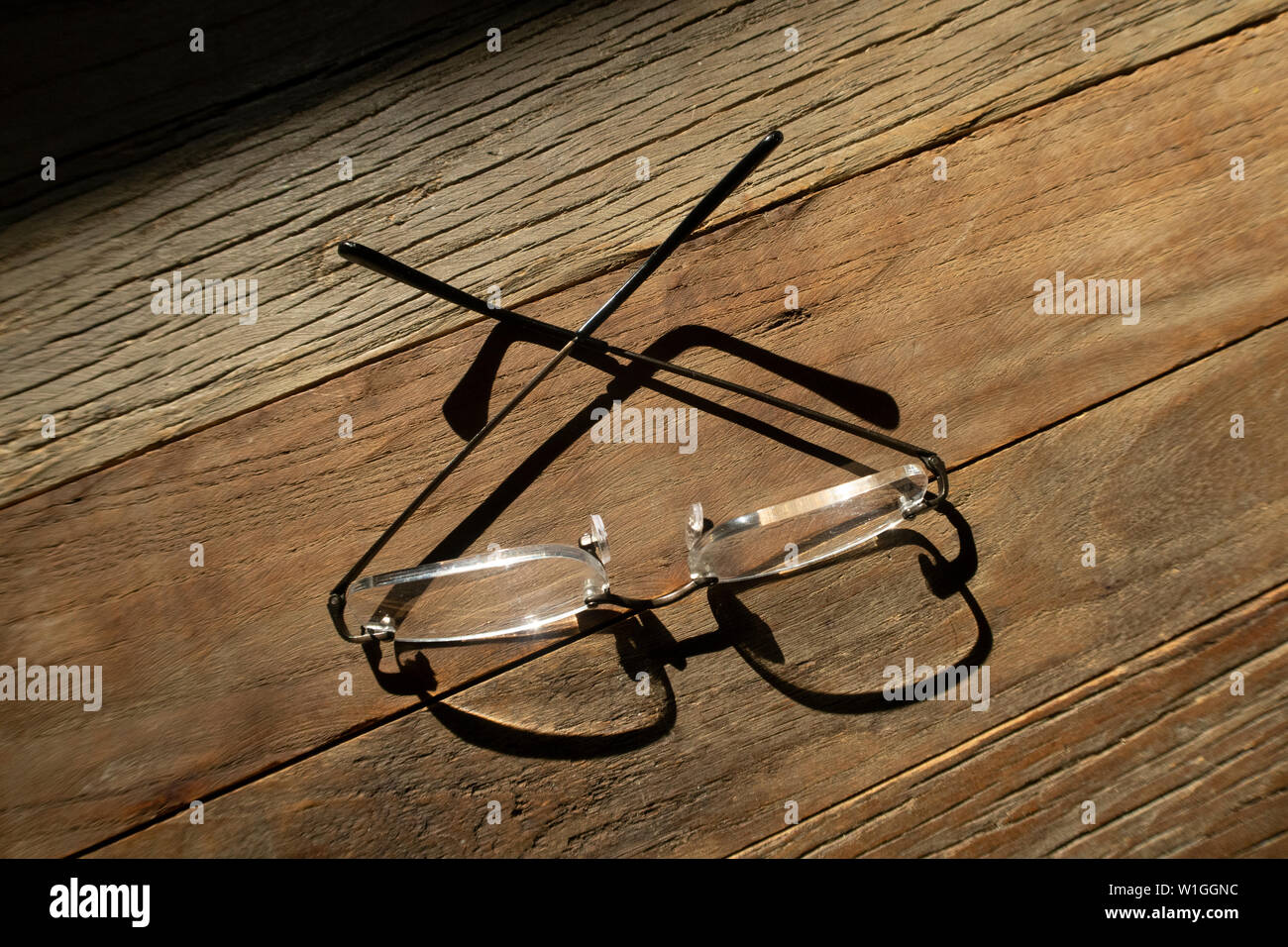 eye glasses folded up on a wooden table Stock Photo