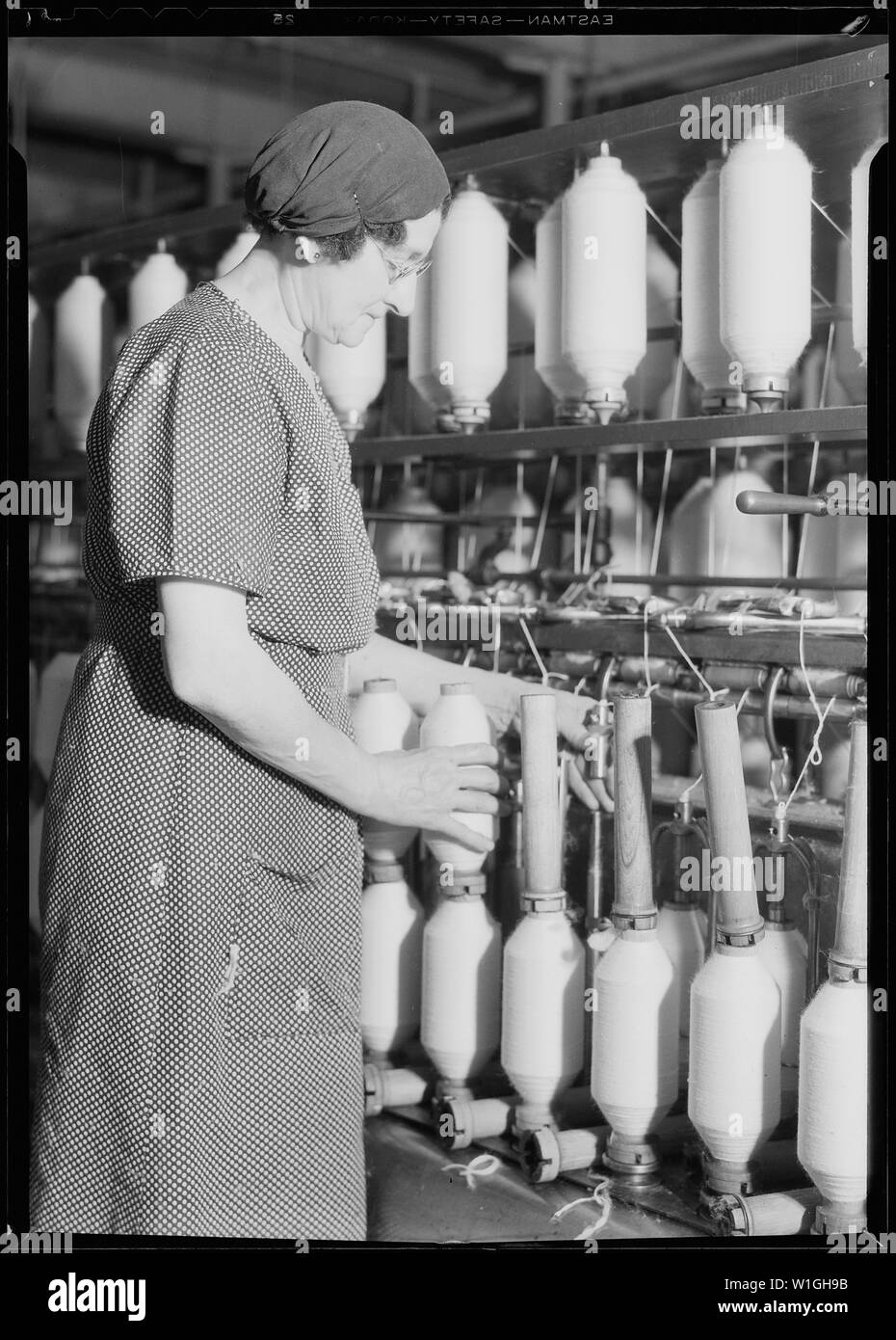 Manchester, New Hampshire - Textiles. Pacific Mills. Roving, a drawing-out process. (Front of machine).  Nederlands: Afzetten (afnemen van de spoelen) van een voorspinmachine. Stock Photo