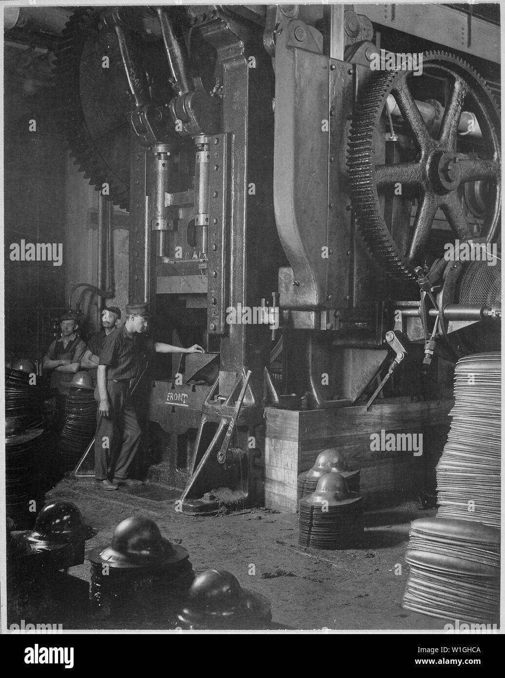 Manufacturing helmets. Large power press for shaping helmets in the plant of Hale & Kilburn Corporation, Philadelphia, Pennsylvania. Hale & Kilburn Company., ca. 1918; General notes:  Use War and Conflict Number 549 when ordering a reproduction or requesting information about this image. Stock Photo