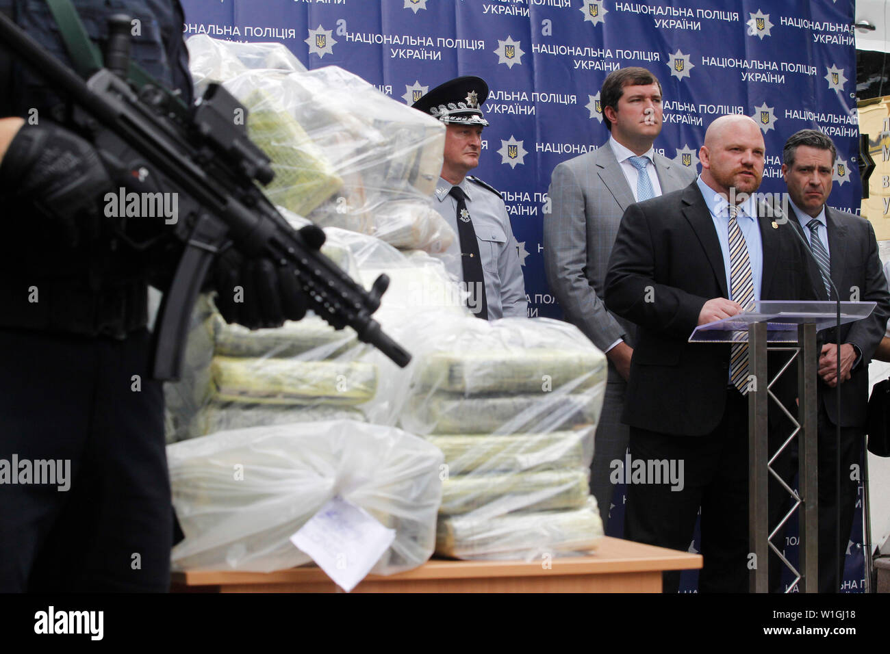 Attache of the Warsaw Office of United States Department of the Drug Enforcement Administration (DEA) Jason Schumacher (2-R) and Deputy Chief Regional Officer for the U.S. Department of the Drug Enforcement Administration (DEA) Kevin Daniels (R)  speaks while standing next to bags of cocaine, which were seized during a special police operation, at a press conference of the National Police and the Anti-Narcotic Police Department and the U.S. Department of the Drug Enforcement Administration (DEA) in the Ministry of Internal Affairs in Kiev.Ukrainian police in cooperation with the U.S. DEA revea Stock Photo