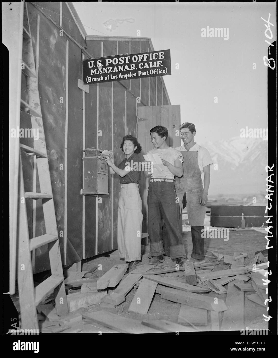 Manzanar Relocation Center, Manzanar, California. Evacuees of Japanese ancestry are enjoying postal . . .; Scope and content:  The full caption for this photograph reads: Manzanar Relocation Center, Manzanar, California. Evacuees of Japanese ancestry are enjoying postal service at this War Relocation Authority center. This is a branch of the Los Angeles Post Office, more than 250 miles away and a two-cent stamp will send a letter to and from Los Angeles. Stock Photo