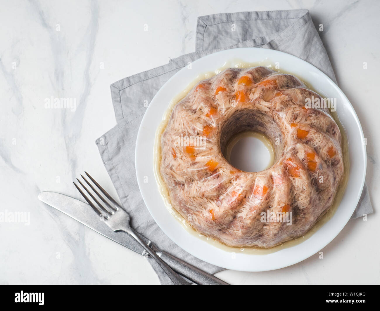 Homemade delicious jelly meat on white marble table. Perfect jellied