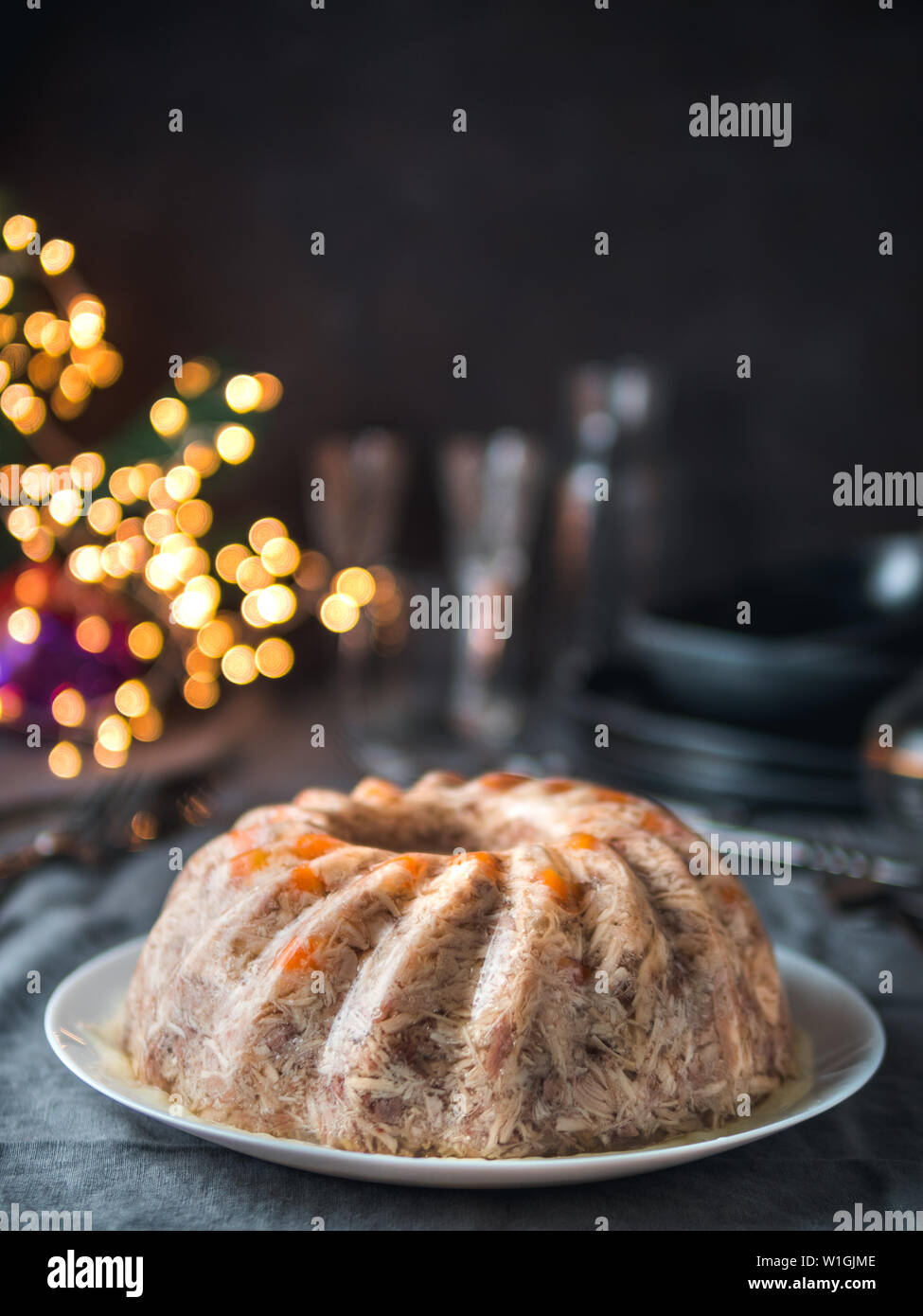 Homemade delicious jelly meat on festive Christmas table. Perfect jellied meat, aspic, galantine with carrot. Copy space for text. Vertical. Stock Photo