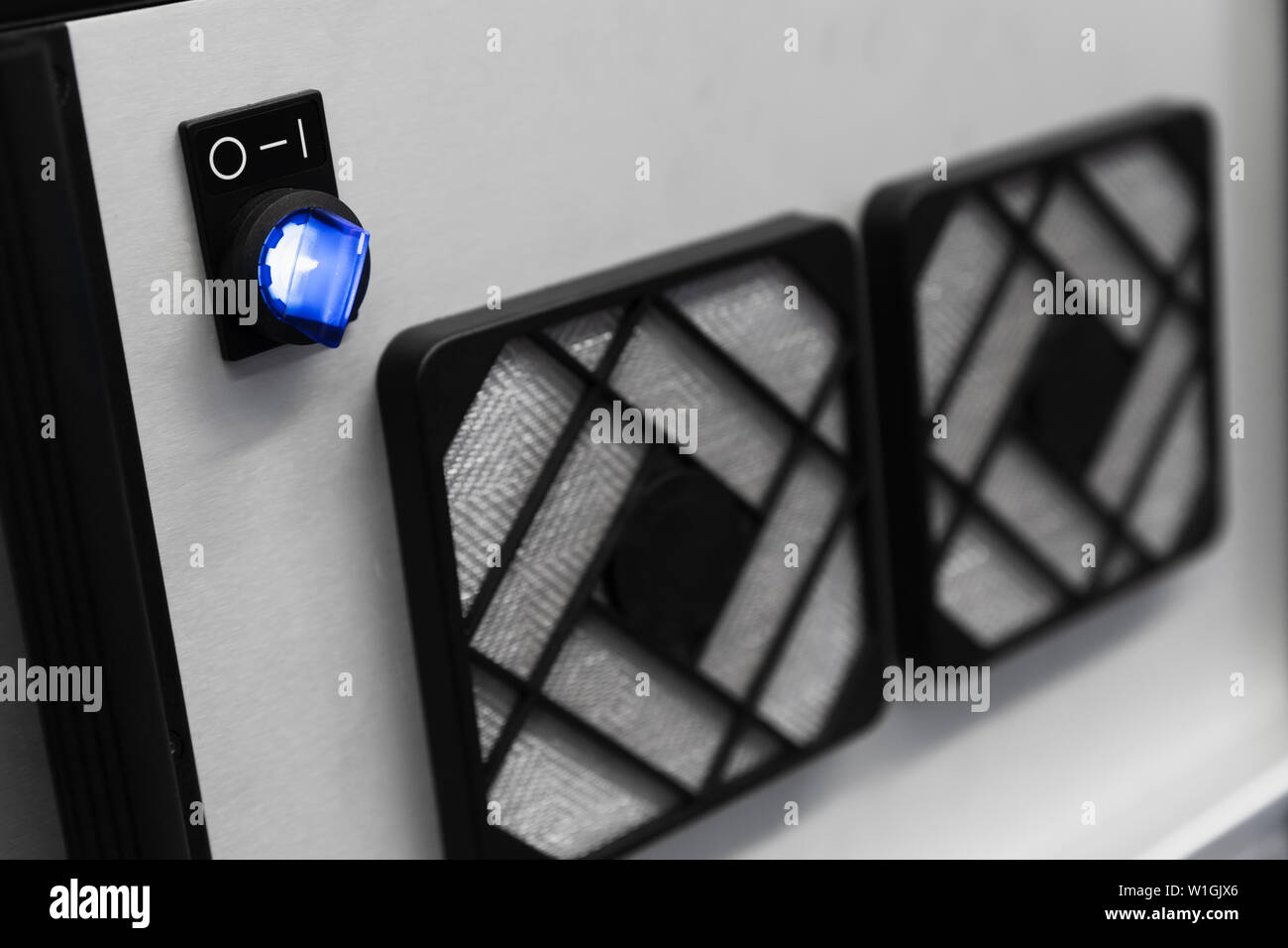Industrial fan panel with blue on off switch, close up photo with soft