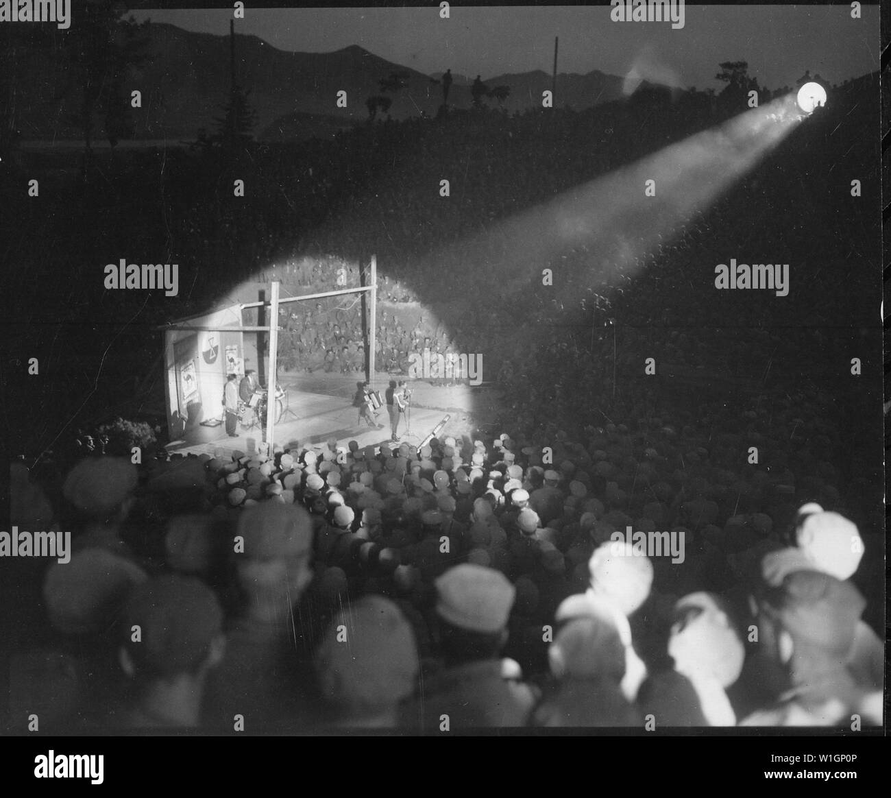 Men of 92nd Engineer Searchlight Company focus on Yodeler Elton Britt during Camel Caravan variety show at Hongchon, Korea.; General notes:  Use War and Conflict Number 1465 when ordering a reproduction or requesting information about this image. Stock Photo