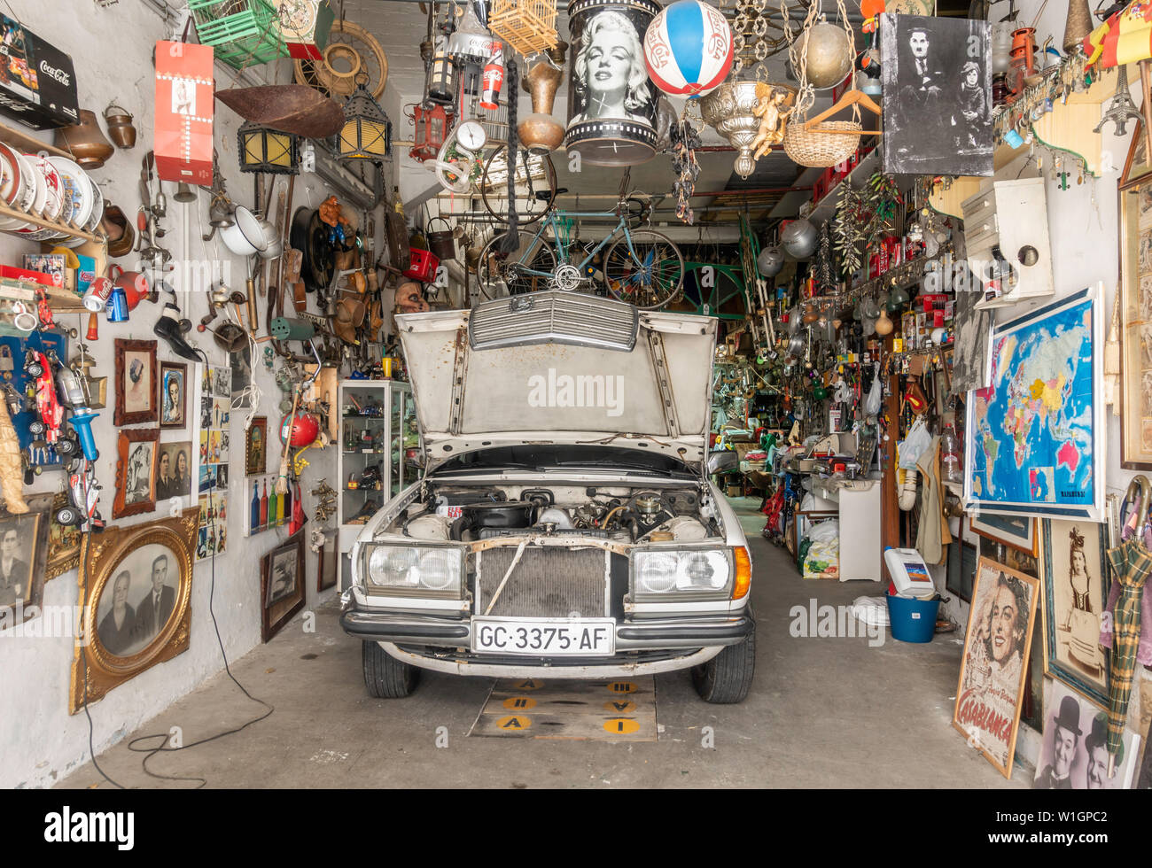 Old Mercedes surrounded by clutter in garage in Spain Stock Photo