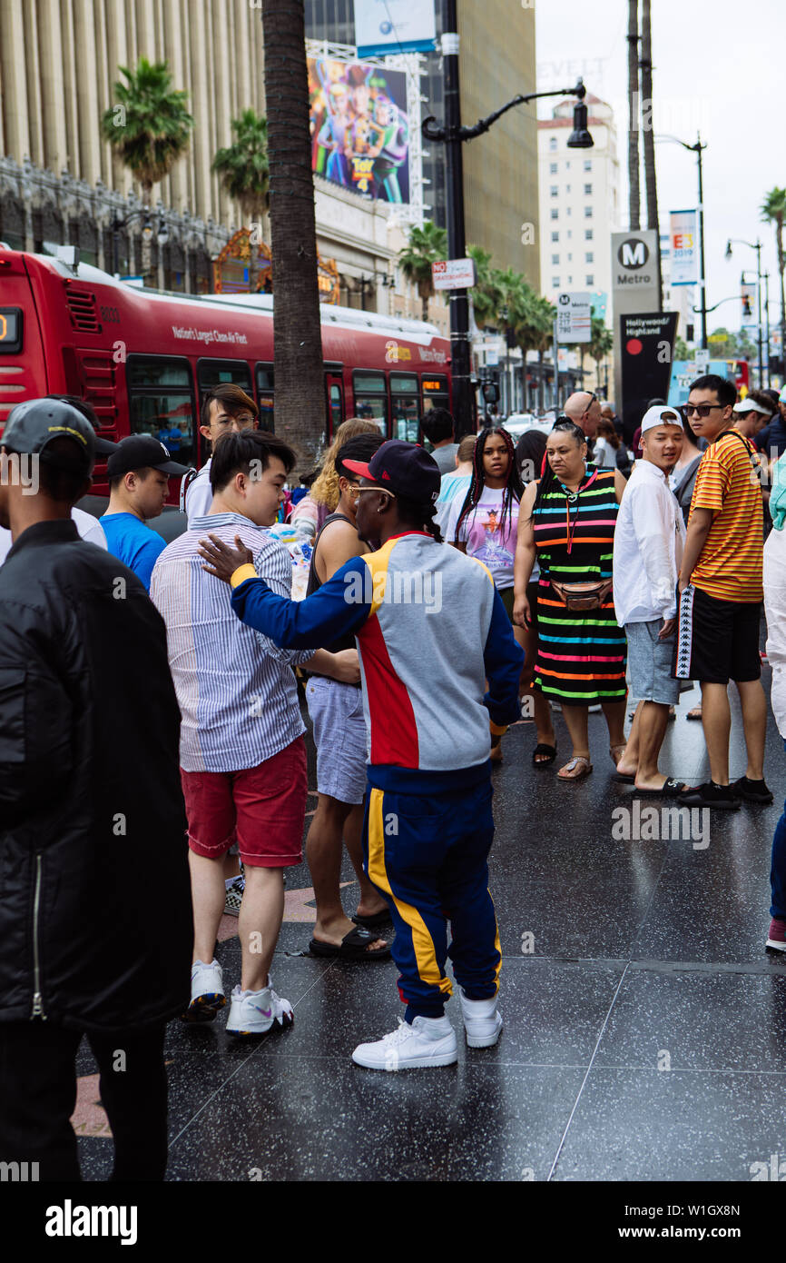 A young afroamerican musician shaking hands of passerby tourist trying to sell CD´s with his music in Hollywood Boulevard, Los Angeles, California Stock Photo