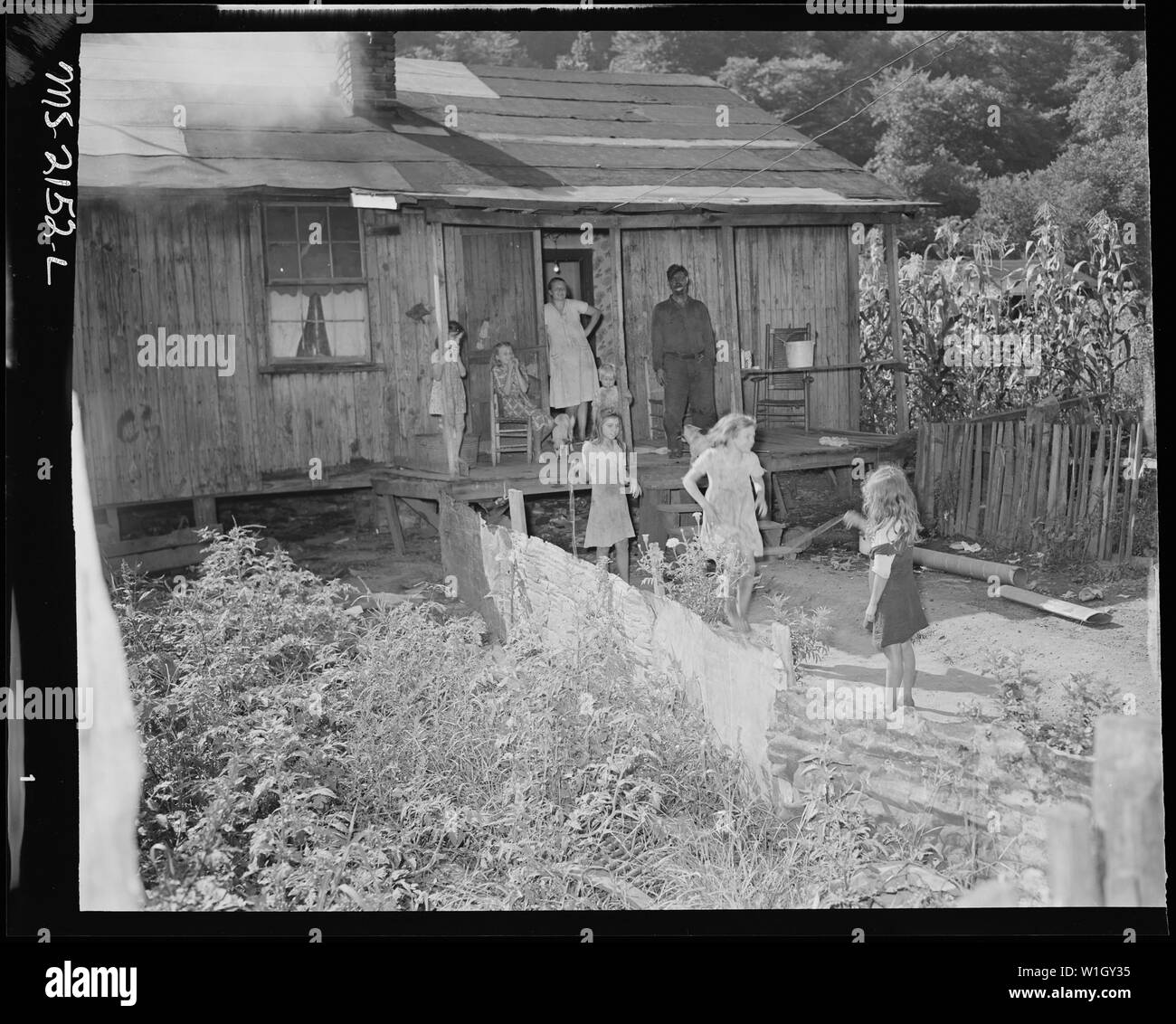 Mr. and Mrs. Ceph Holland and their six children in front of their three room house about which they said, They (the company) put on a patch now and then and that don't stop it from leaking. Fox Ridge Mining Company, Inc., Hanby Mine, Arjay, Bell County, Kentucky Stock Photo