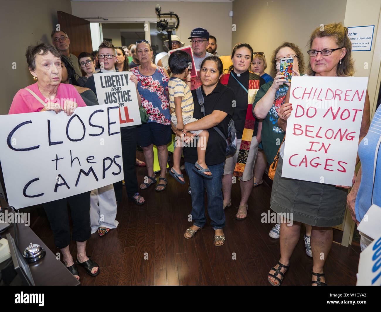 July 2, 2019 - Des Moines, Iowa, U.S - Protesters stand in the lobby of Rep. Cindy Axen's office. About 150 people came to Congresswoman Axne's office in Des Moines Tuesday to protest the treatment of migrant children detained by the US Border Patrol along the US/Mexico border. Axne was not in the office, but a member of Axne's staff took notes and promised to pass people's concerns on to the Congresswoman. Similar protests were held at other congressional offices and Immigration and Customs Enforcement (ICE) detention facilities across the country. (Credit Image: © Jack Kurtz/ZUMA Wire) Stock Photo