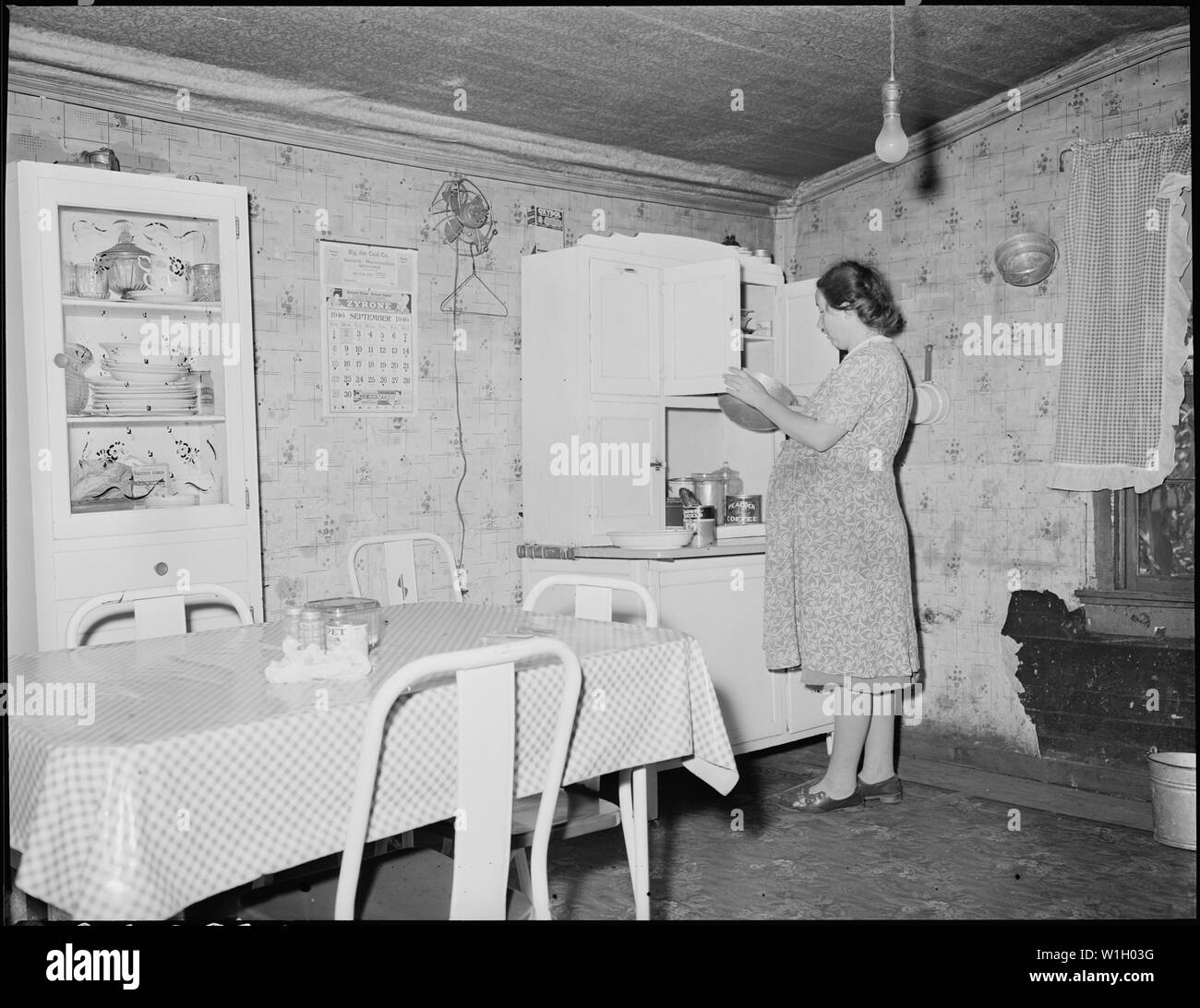 Mrs. Floyd Miller, wife of a miner, in the kitchen of their three room house for which they pay $6 monthly. They pay $3 monthly for electricity and have an iron, radio, washing machine, and three drops. Big Jim Coal Company, Big Jim Mine, Blanche, Bell County, Kentucky. Stock Photo