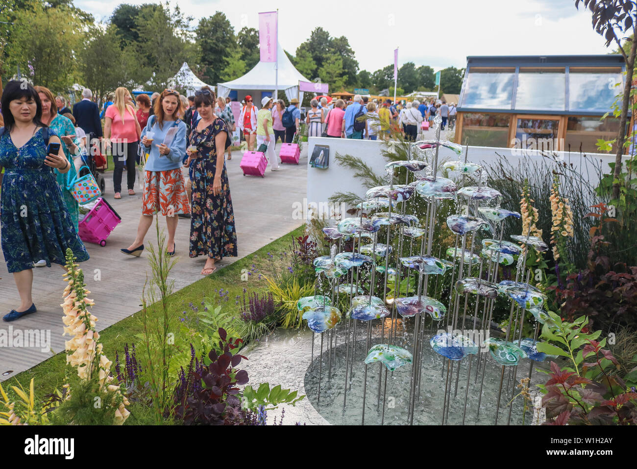 Visitors view a water sculpture during the festival.The Royal Horticultural  Society (RHS) Hampton Court Garden Festival, showcases plant and flower  exhibits at Hampton Court Palace in London Stock Photo - Alamy