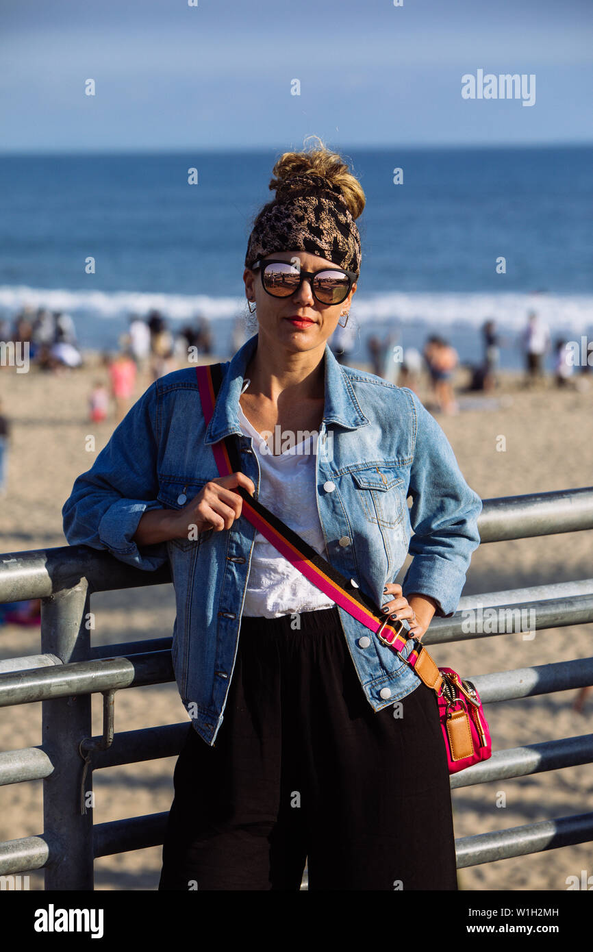 Middle age woman posing with shades in Santa Monica Pier and Beach, Los Angeles, California Stock Photo