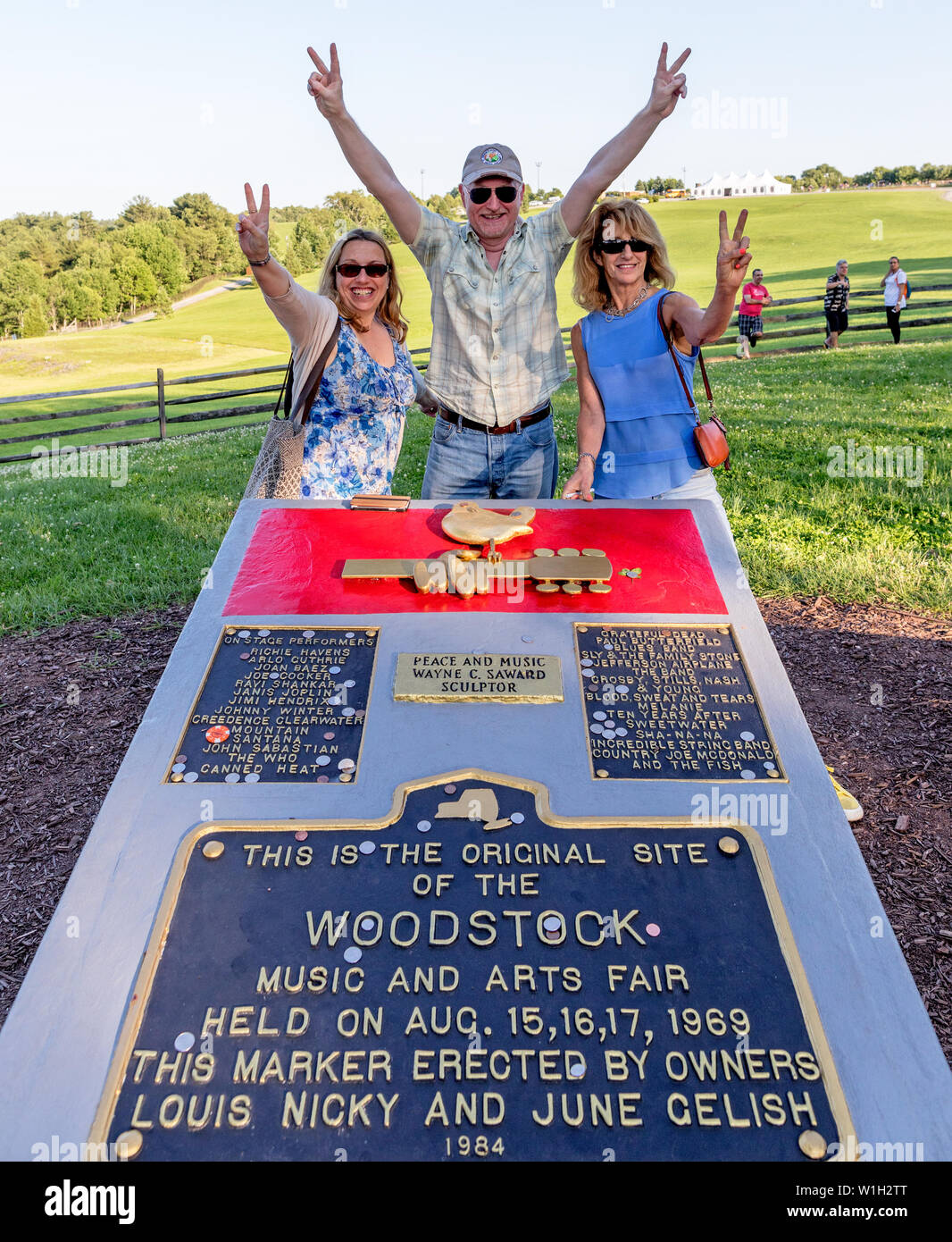 People at The Memorial Stone at The Site of The Woodstock Festival At