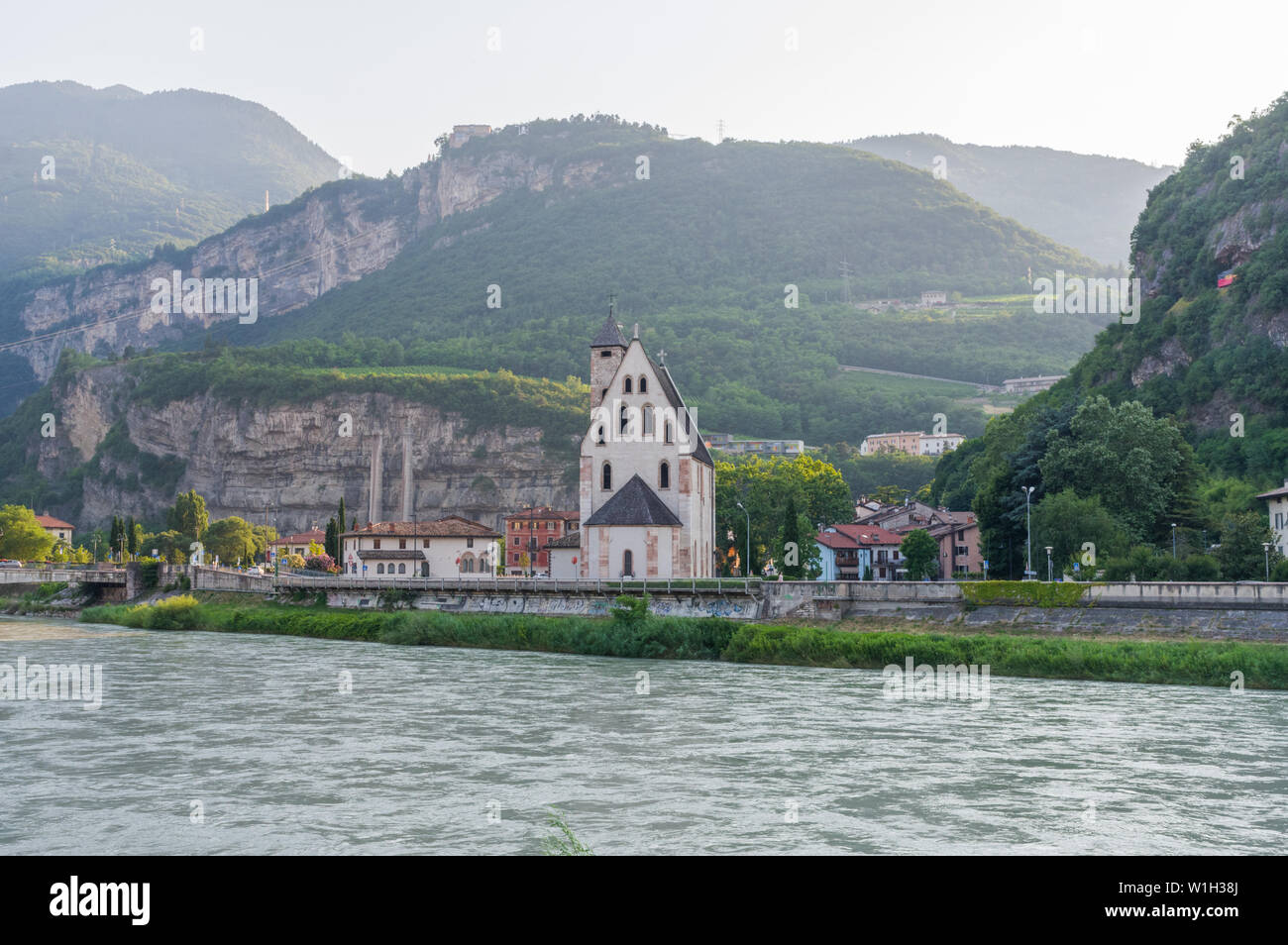 Trento, Italy (30th June 2019) - The church of St. Apollinare, built in the XIII Century, on the shoreline of the river Adige Stock Photo