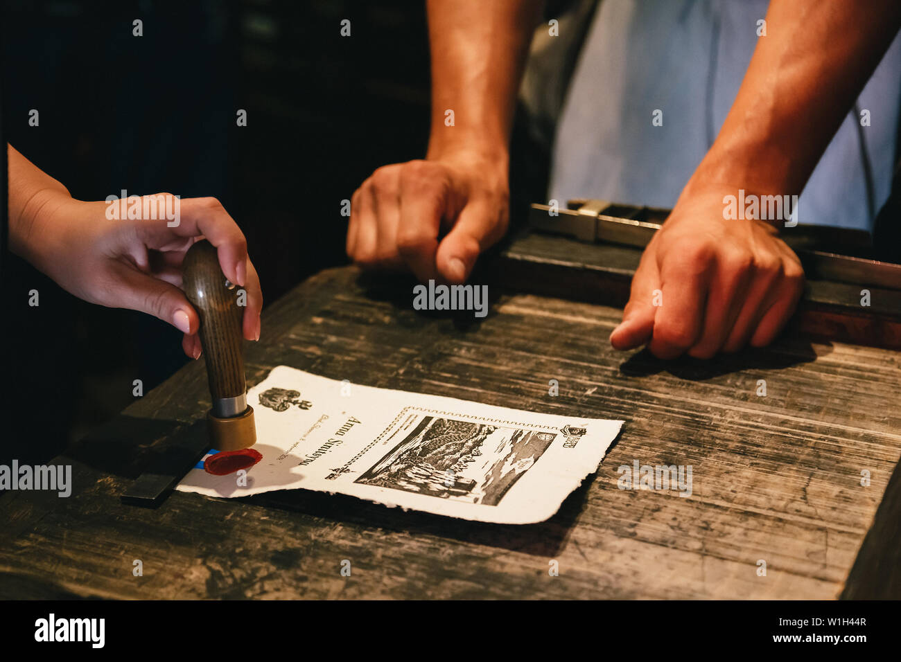 Bled, Slovenia - September, 8 2018: Close up of woman's hands making a souvenir by herself, making a personal stamp of melted red sealing wax at old-s Stock Photo