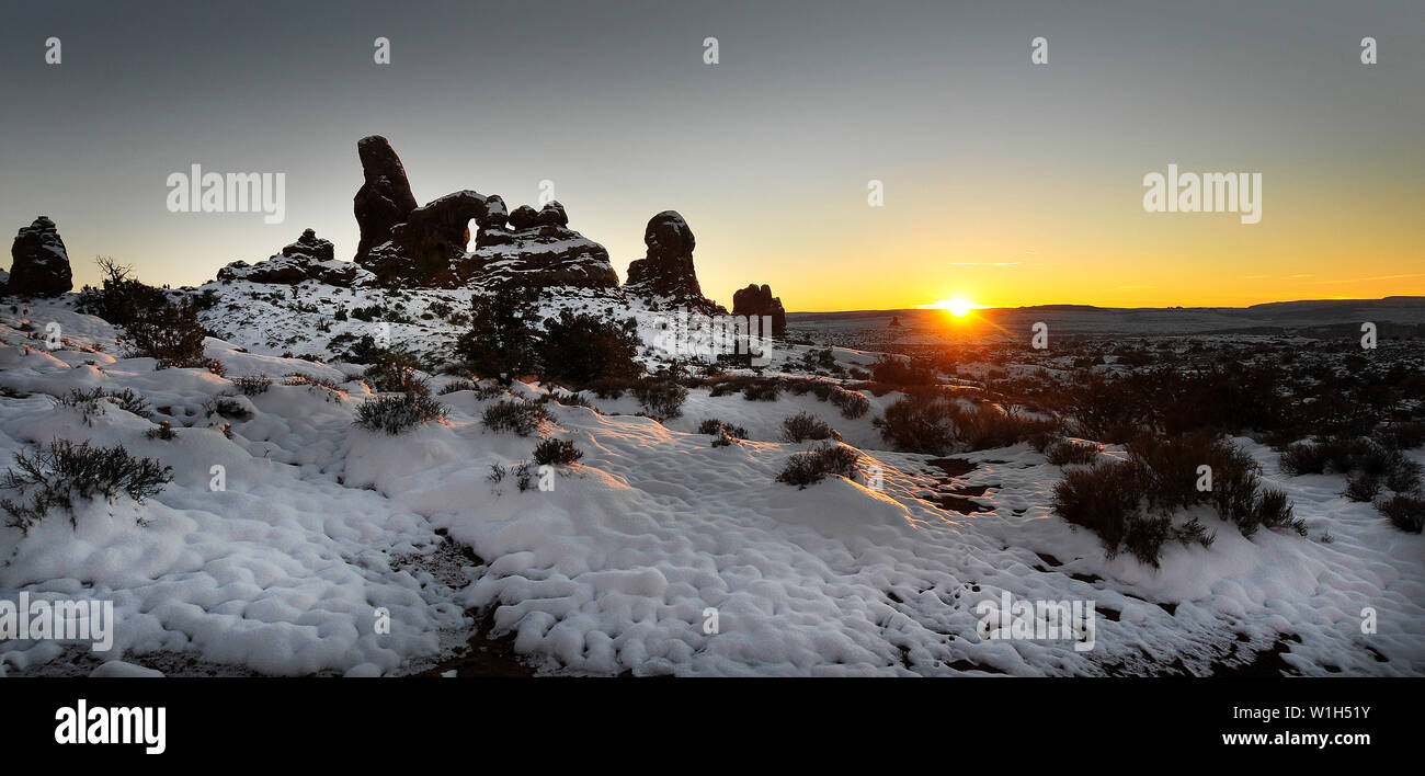 The sun sets on Turret Arch in Arches National Park as freshly fallen snow forms a pattern on the desert floor. (c) 2012 Tom Kelly Stock Photo