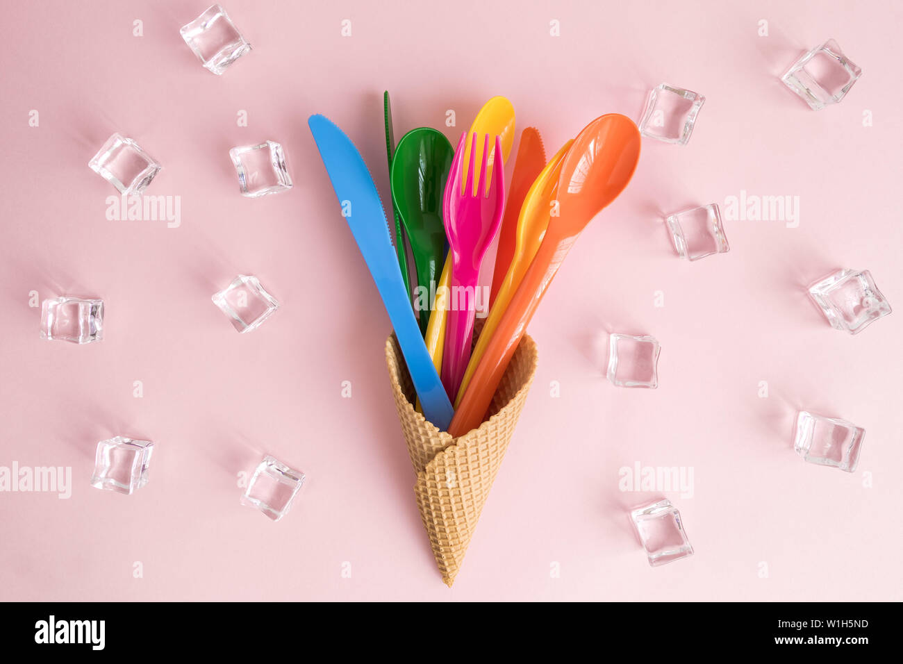 High angle view of forks, spoons and knives in ice cream cone with ice