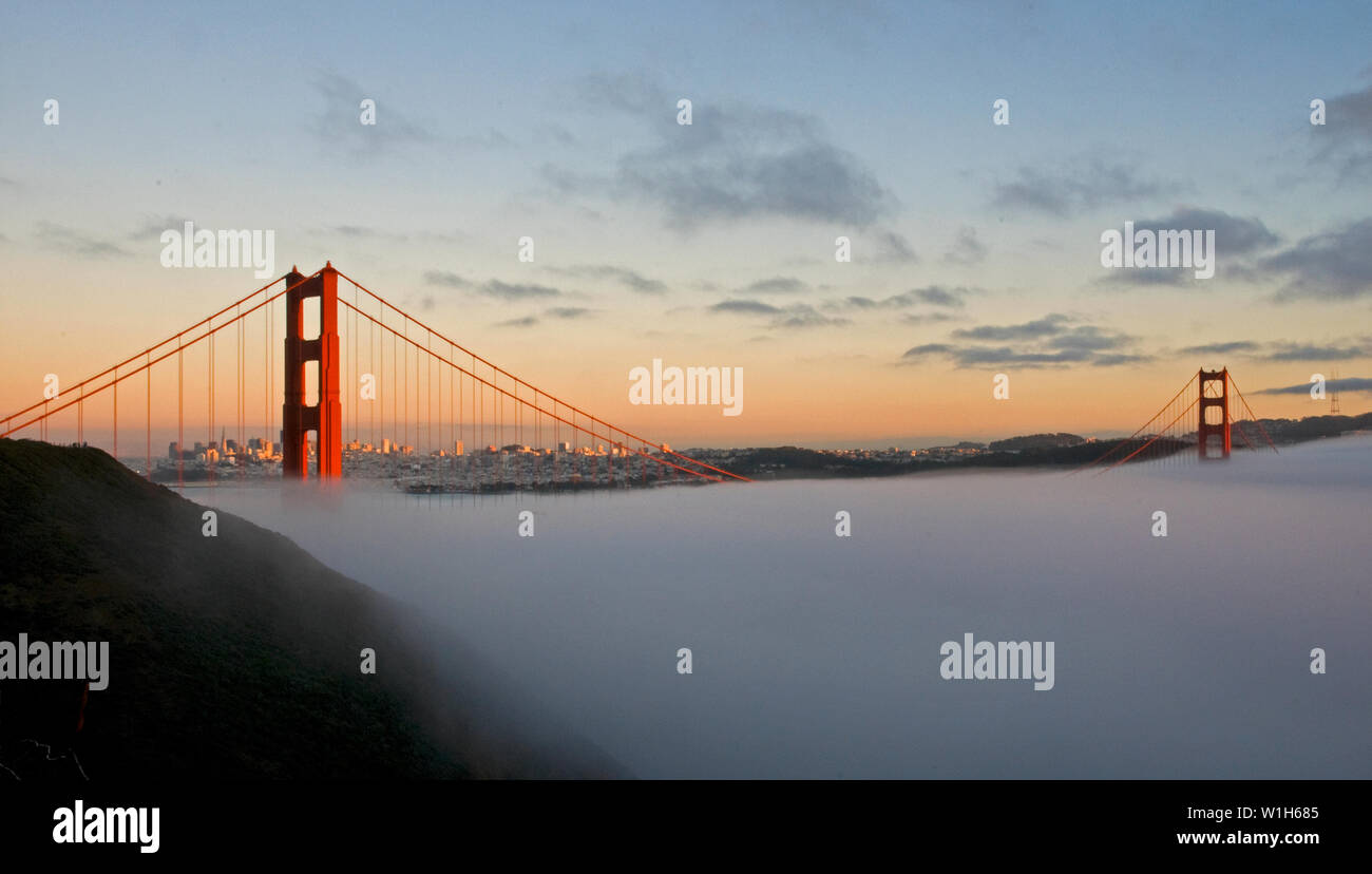 The towers of San Francisco's Golden Gate Bridge stand out from fog settling over the Marin Headlands at sunset. (c) 2009 Tom Kelly Stock Photo