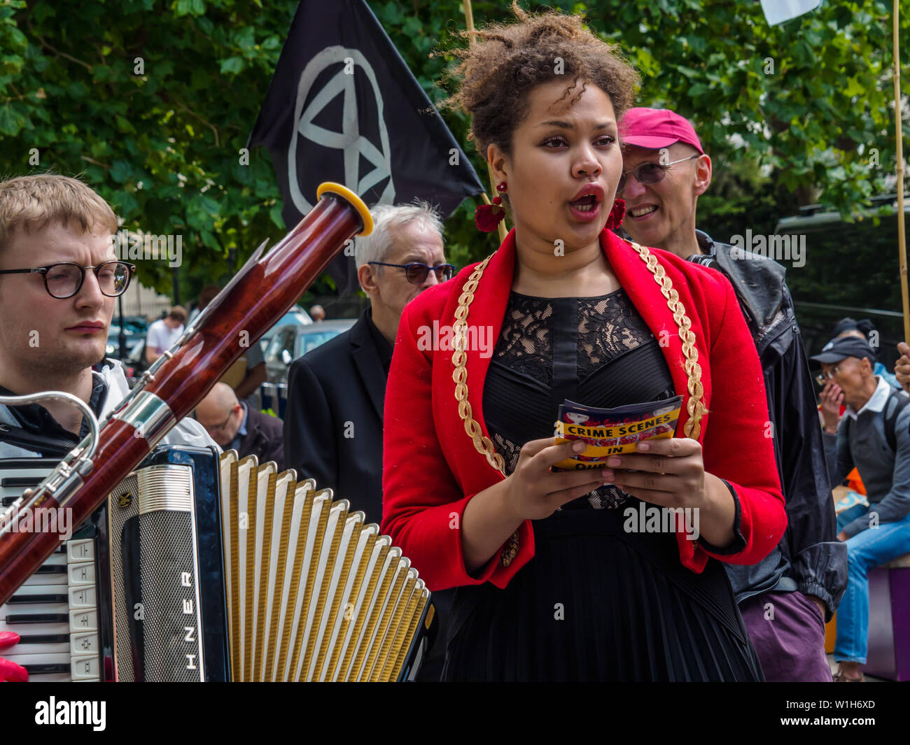 London, UK. 2nd July 2019. An opera singer performs during the procession by Extinction Rebellion to offices oil companies in the Oil and Gas Climate Initiative (OGCI) urging them to abandon the pretence they can combat global warming without a huge cut in oil production. The protest on the day that BP were sponsoring a Royal Opera House performance of Carmen to be relayed to 13 BP big screens starred Carmen speaking, a fine opera singer and XR drummers and a team marking the companies as crime scenes. Peter Marshall/Alamy Live News Stock Photo