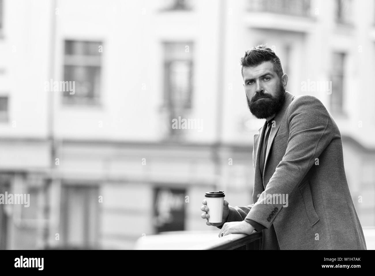 Relax and recharge. Man bearded hipster drinking coffee paper cup. One more sip of coffee. Enjoying coffee on the go. Businessman well groomed appearance enjoy coffee break out of business center. Stock Photo