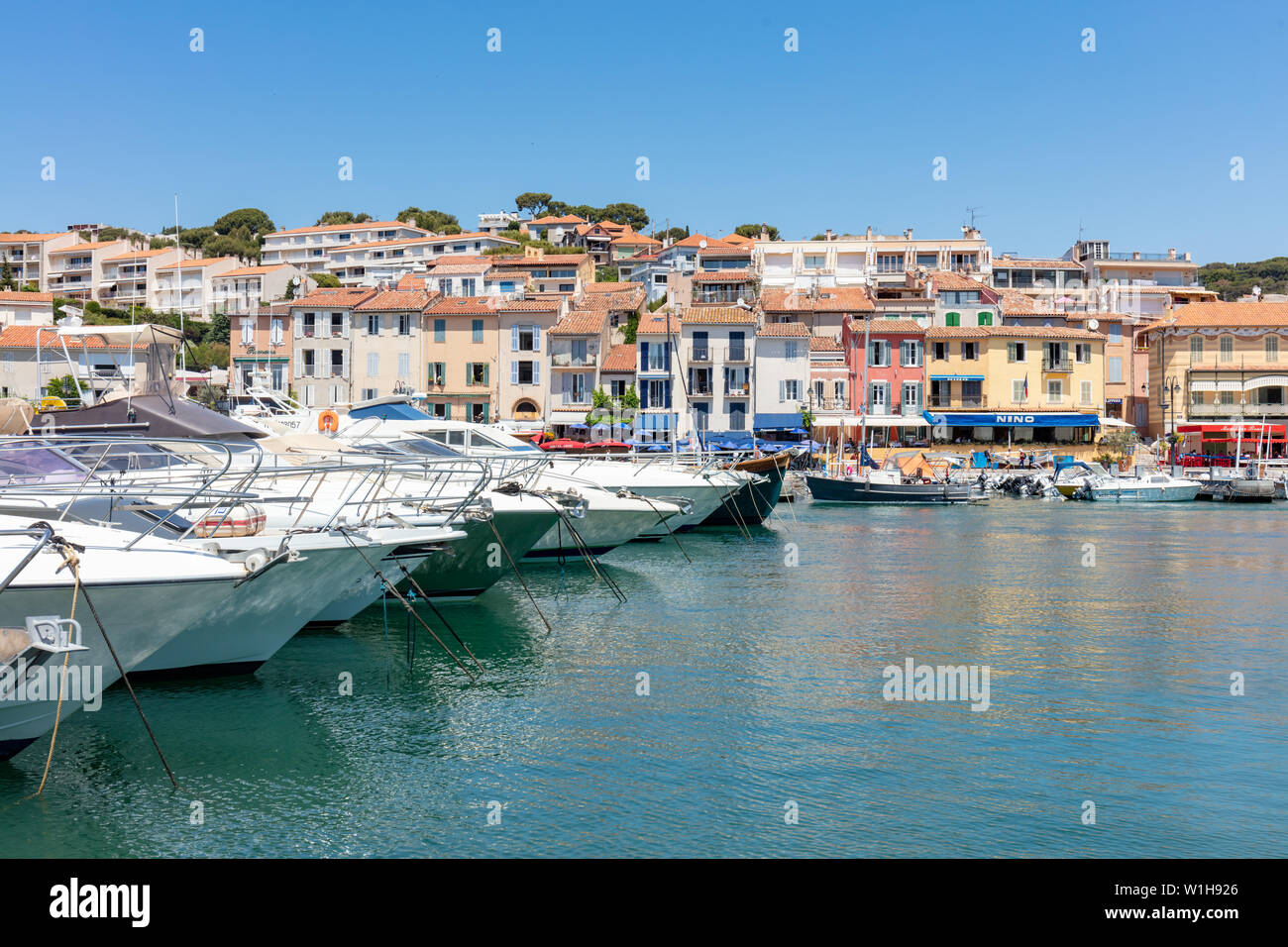 Cassis, France; 22nd June 2019; Leisure Boats Lined Up in the Harbour With Colourful Buildings Behind Stock Photo