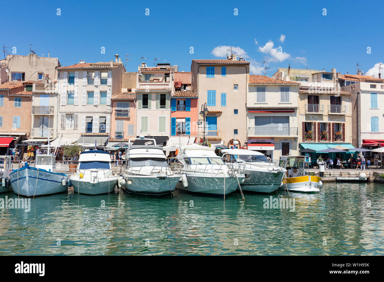 Cassis, France; 22nd June 2019; Line of  Boats Moored With Colourful Buildings Behind Stock Photo