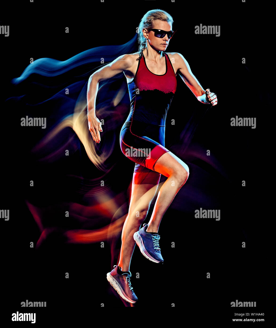 one caucasian woman triathlon triathlete runner running joogger jogging  studio shot isolated on black background with light painting effect Stock  Photo - Alamy