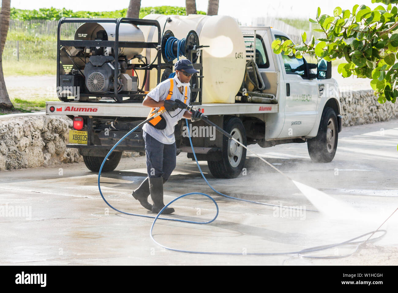 Miami Beach Florida,Lummus Park,city maintenance worker,workers,pressure clean,hose,truck,water tank,concrete,Black woman female women,working,work,em Stock Photo