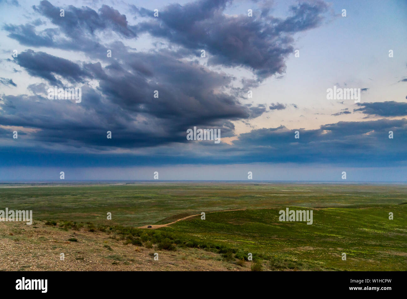 Scenic sunset with clouds in sky in steppe. Stock Photo