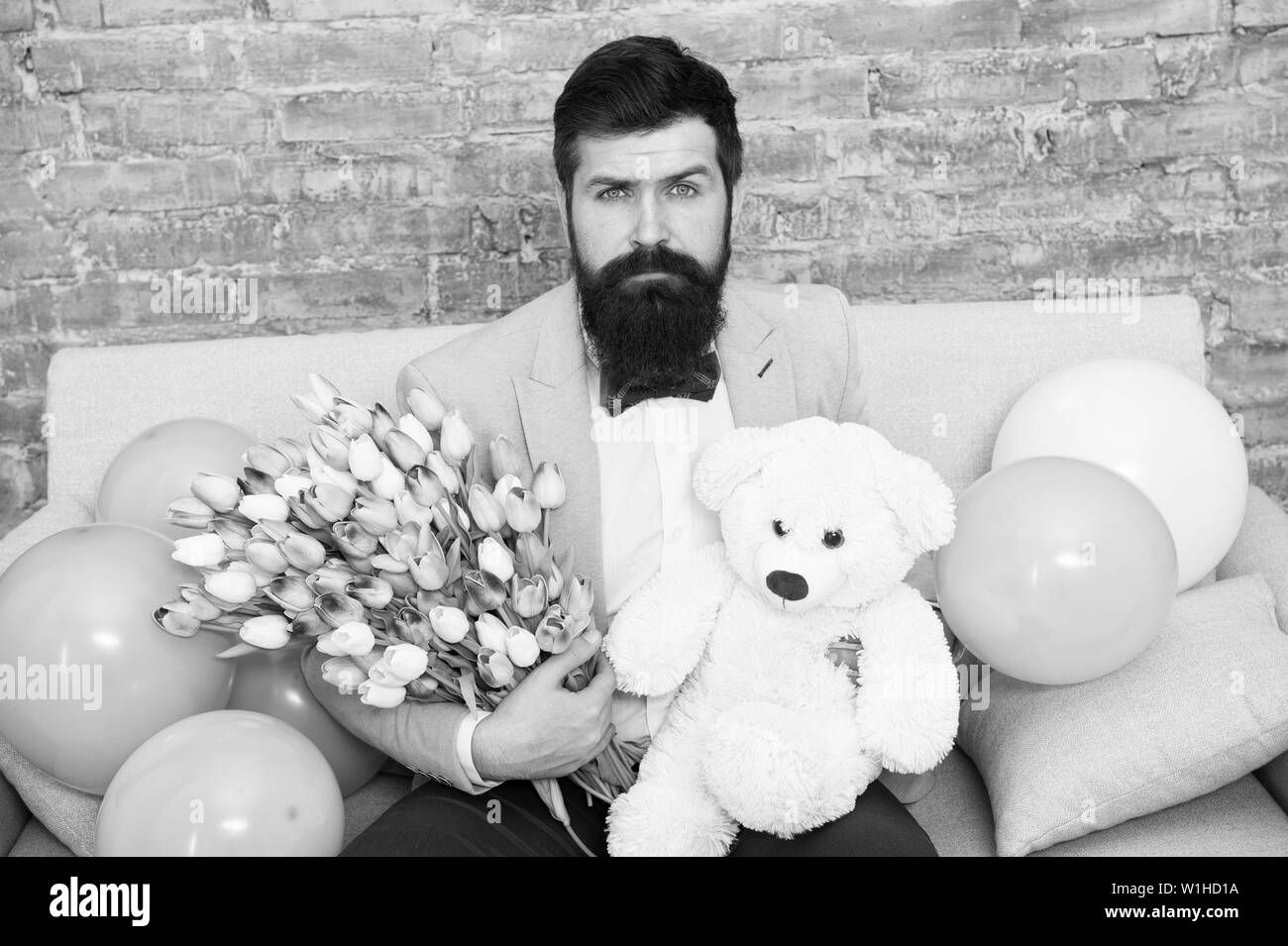 The quickest way to show you care. Love spring. international spring holiday. Spring gift. Bearded man hipster with spring flowers. Flower for March 8. Womens day. Bearded man with tulip and bear. Stock Photo