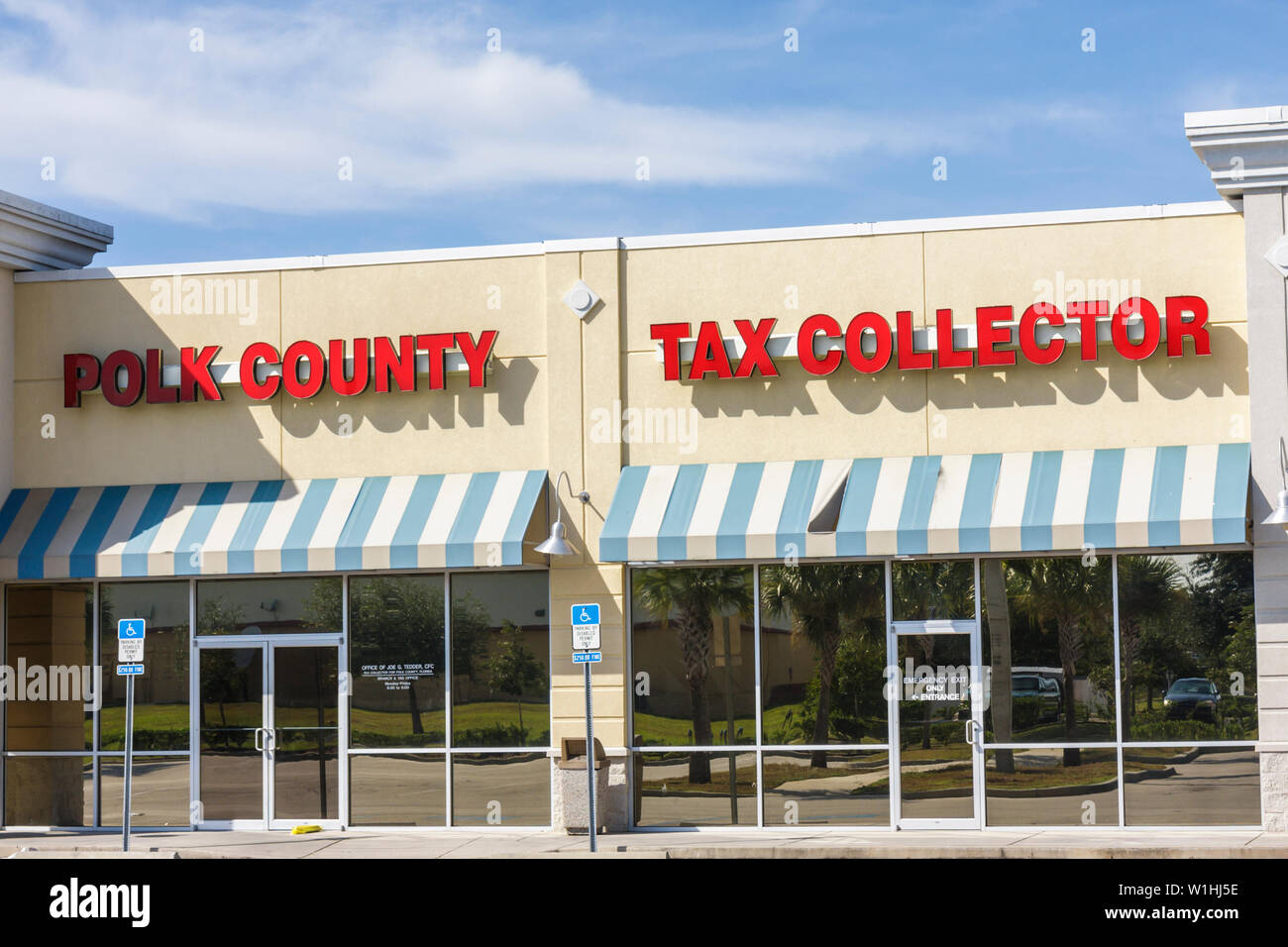 Lake Wales Florida,strip mall,store front,Polk County Tax Collector,awning,parking spaces,handicap space,sign,government agency,office,glass reflectio Stock Photo