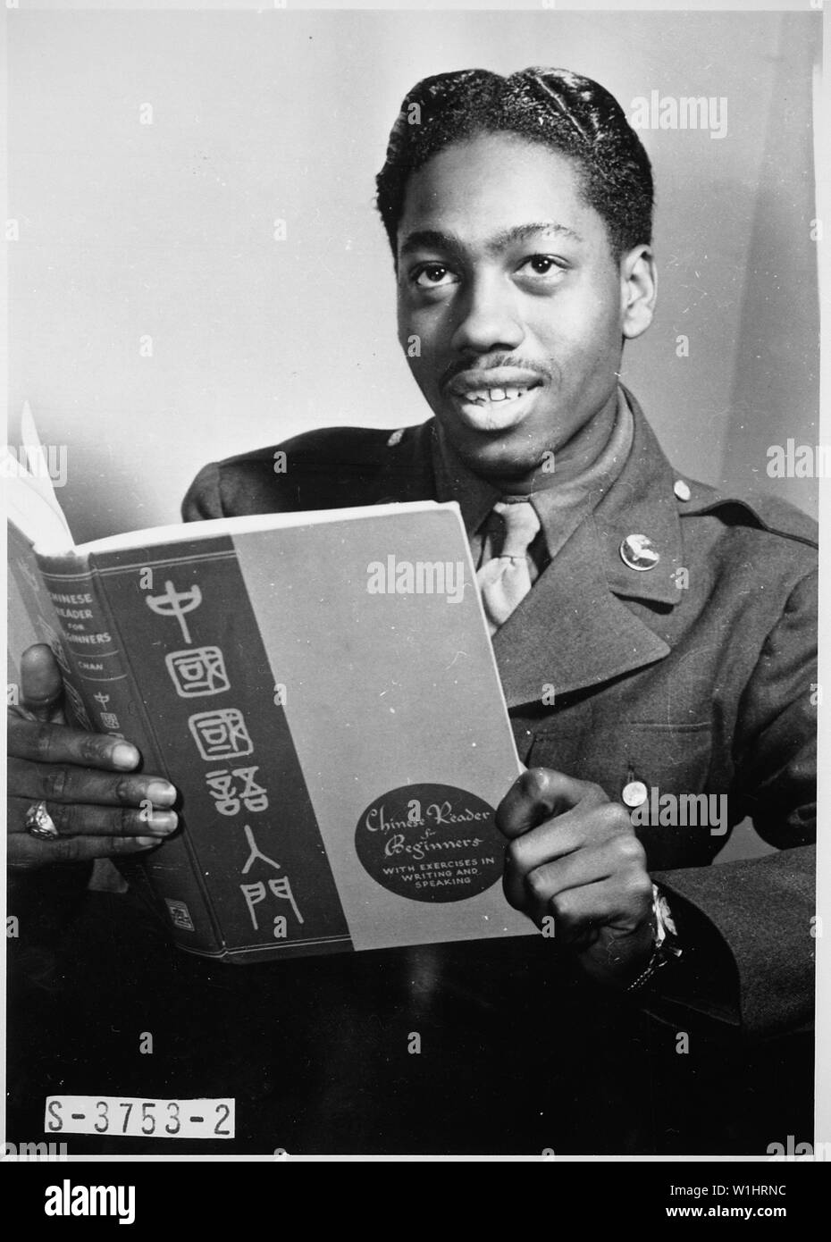 Pvt. Lloyd A. Taylor, 21-year-old transportation dispatcher at Mitchel Field, New York City, who knows Latin, Greek, Spanish, French, German, and Japanese, studies a book on Chinese. A former medical student at Temple University, he passes two hours a day studying languages as a hobby., ca. 1941 - ca. 1945 Stock Photo