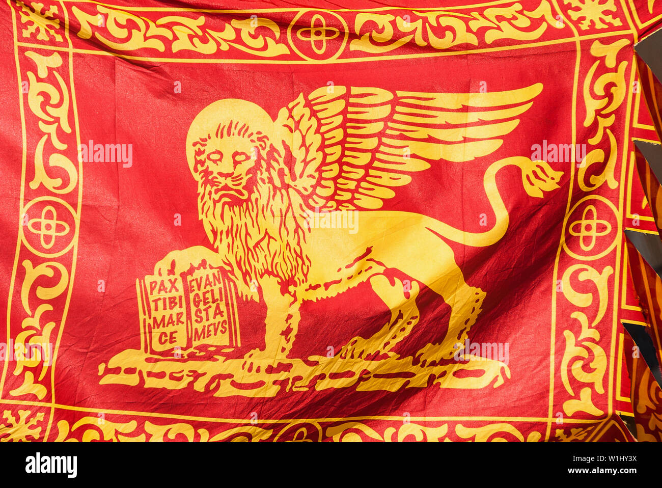 Old Venice Republic Flag with Saint Mark Lion and motto 'Pax tibi Marce, evangelista meus' (Peace be with thee, O Mark, my evangelist) fluttering in t Stock Photo