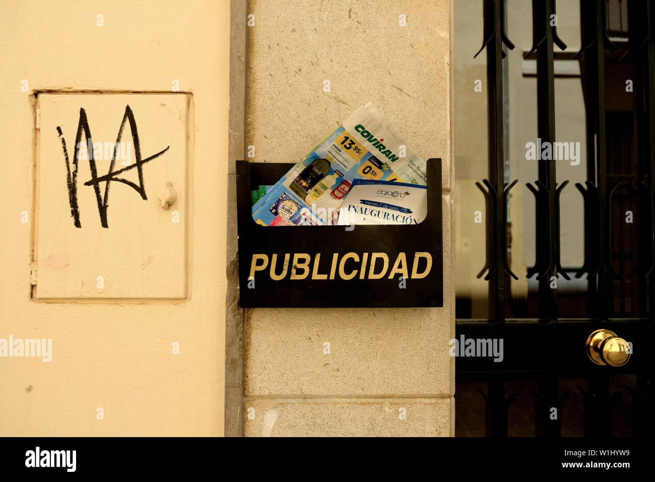 Publicidad mailbox with delivered publicity flyers and circulars on a wall outside an apartment in Granada, Spain; publicity in Spanish. Stock Photo