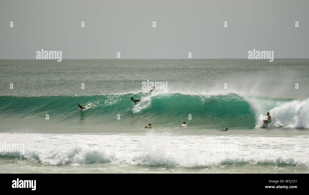wide shot of surfers riding a wave at kirra Stock Photo