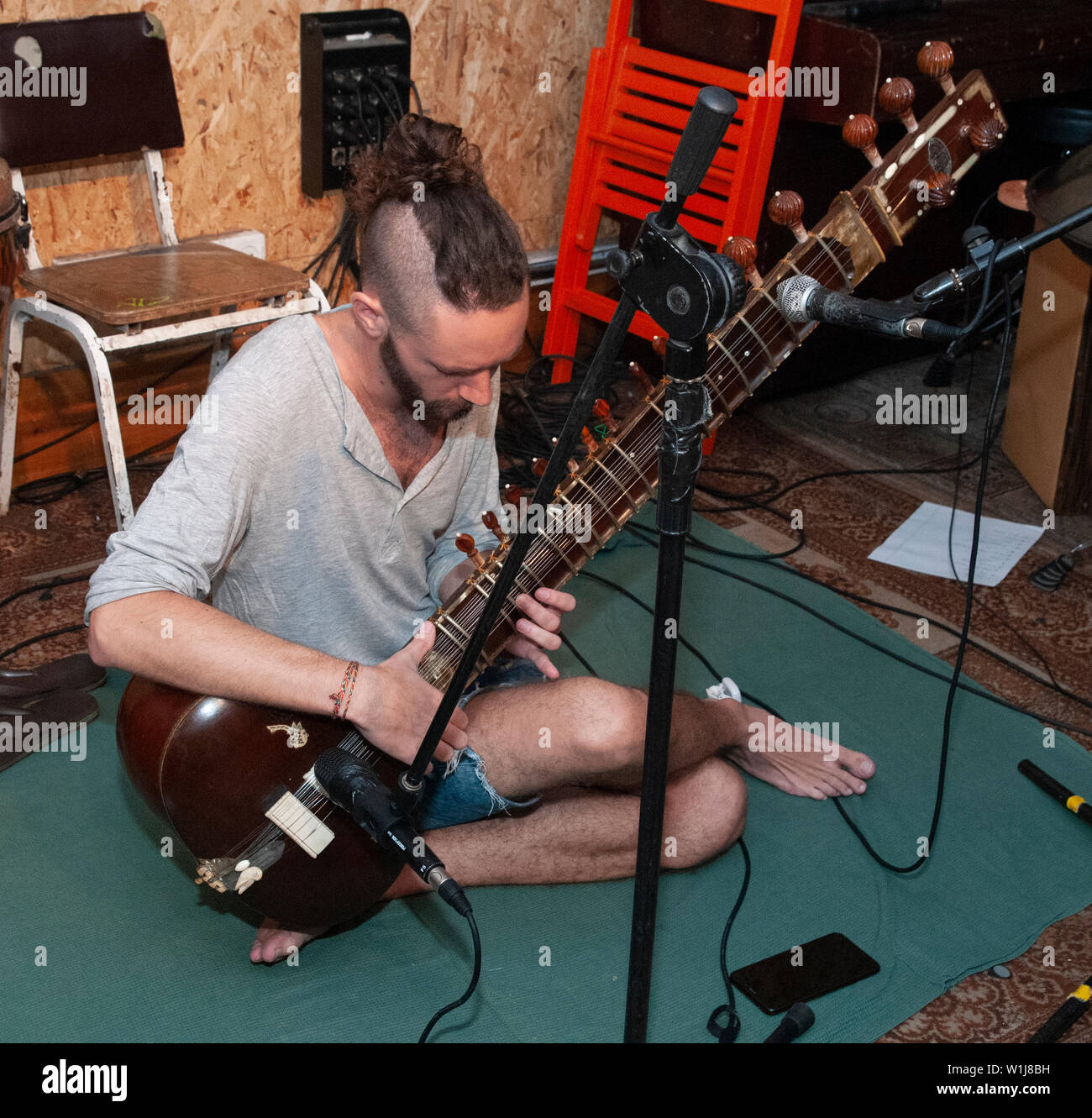 Young Caucasian musician plays a Sitar Stock Photo