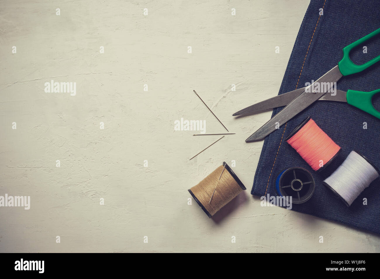 Sewing tools and equipment on white wooden floor. Top view and copy space for text. Concept of tailor or fashion designer. Stock Photo