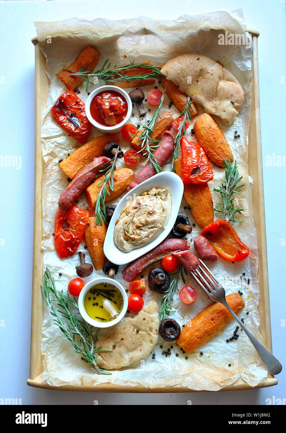 Grilled sausages and vegetables platter served with humus and pita