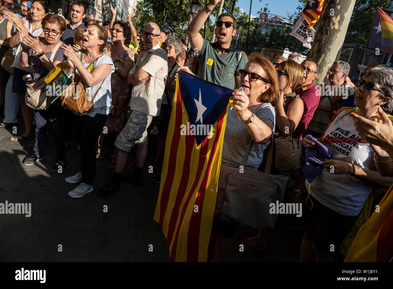 Barcelona, Spain. 02nd July, 2019. A woman shows off an independence flag during the demonstration.In correspondence with the rallies in front of the European Parliament in Strasbourg, hundreds of supporters for the independence of Catalonia have gathered in front of the headquarters of the European Commission in Barcelona in support of the three elected Catalan deputies to whom the Spanish authorities have prevented their recognition as European parliamentarians given their judicial status. Credit: SOPA Images Limited/Alamy Live News Stock Photo