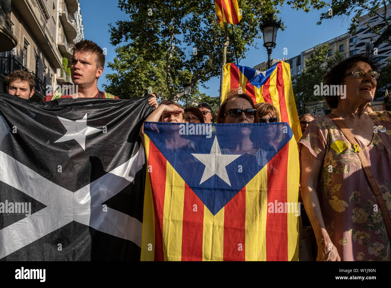 Barcelona, Spain. 02nd July, 2019. Protesters hold flags during the demonstration.In correspondence with the rallies in front of the European Parliament in Strasbourg, hundreds of supporters for the independence of Catalonia have gathered in front of the headquarters of the European Commission in Barcelona in support of the three elected Catalan deputies to whom the Spanish authorities have prevented their recognition as European parliamentarians given their judicial status. Credit: SOPA Images Limited/Alamy Live News Stock Photo