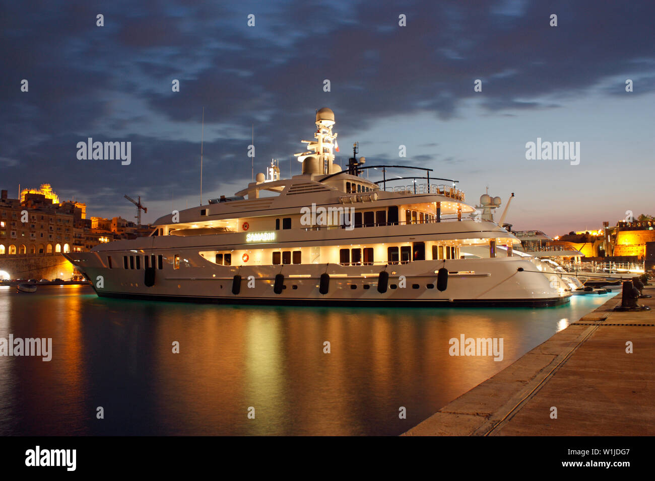 The large Feadship luxury yacht Samadhi in the Grand Harbour Yacht Marina, Malta, at night Stock Photo