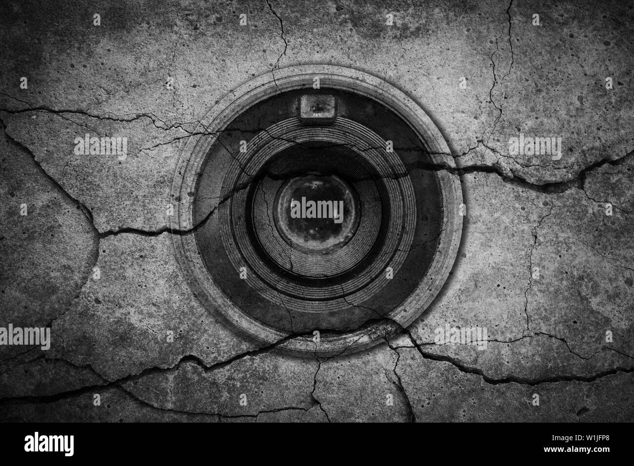 The camera lens is on cracked cement background Stock Photo