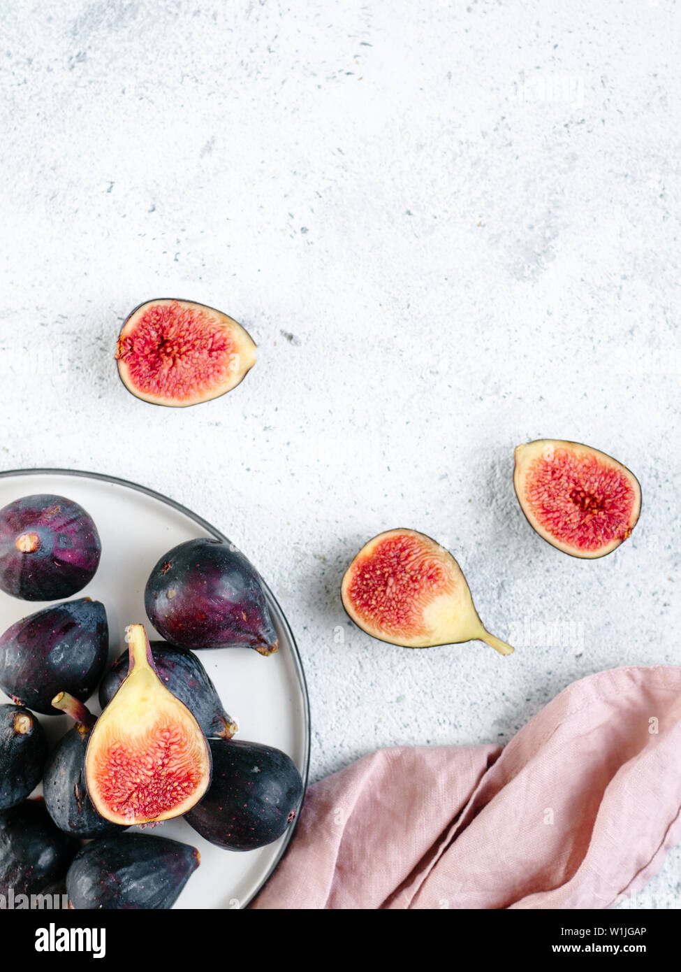 Half and whole figs on gray cement or stone background. Ripe violet