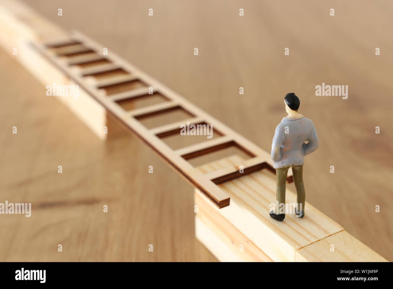 business concept picture of challenge. A man stands on the edge of a high  wall and passes the gap by placing a ladder. Problem solving and  decisionmak Stock Photo - Alamy