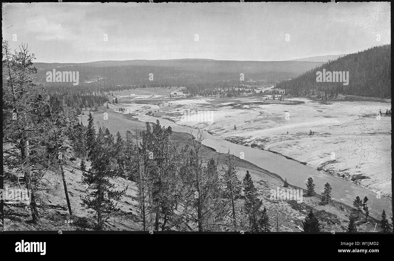 The Excelsior Geyser. Yellowstone National Park; Excelsior Geyser is not actually visible in this image.  Most of what's visible to the right of the Firehole River is runoff from Grand Prismatic Spring. Stock Photo