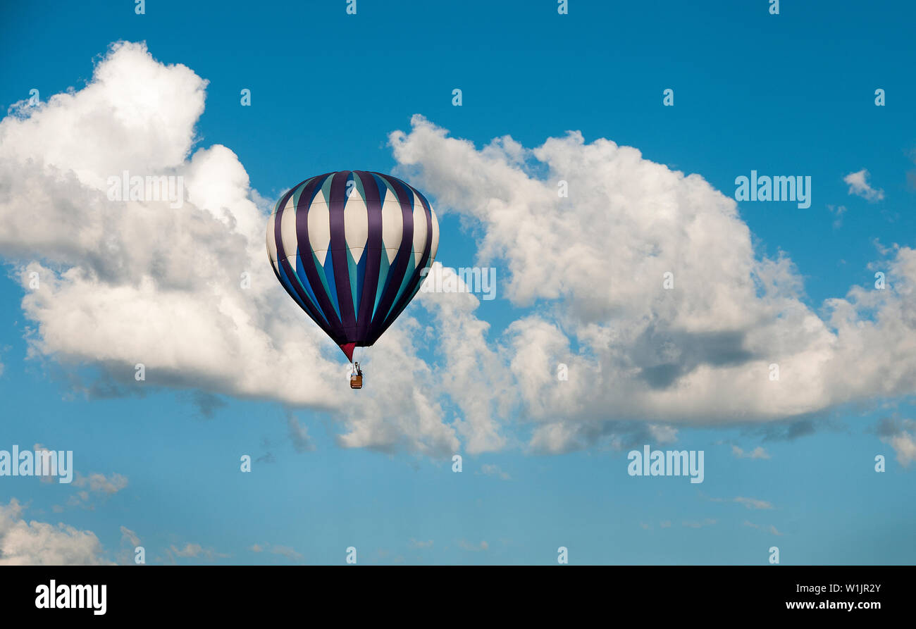 A hot air balloon soars quietly through the clouds high above Silver Creek near Park City, Utah. (c) 2015 Tom Kelly Stock Photo