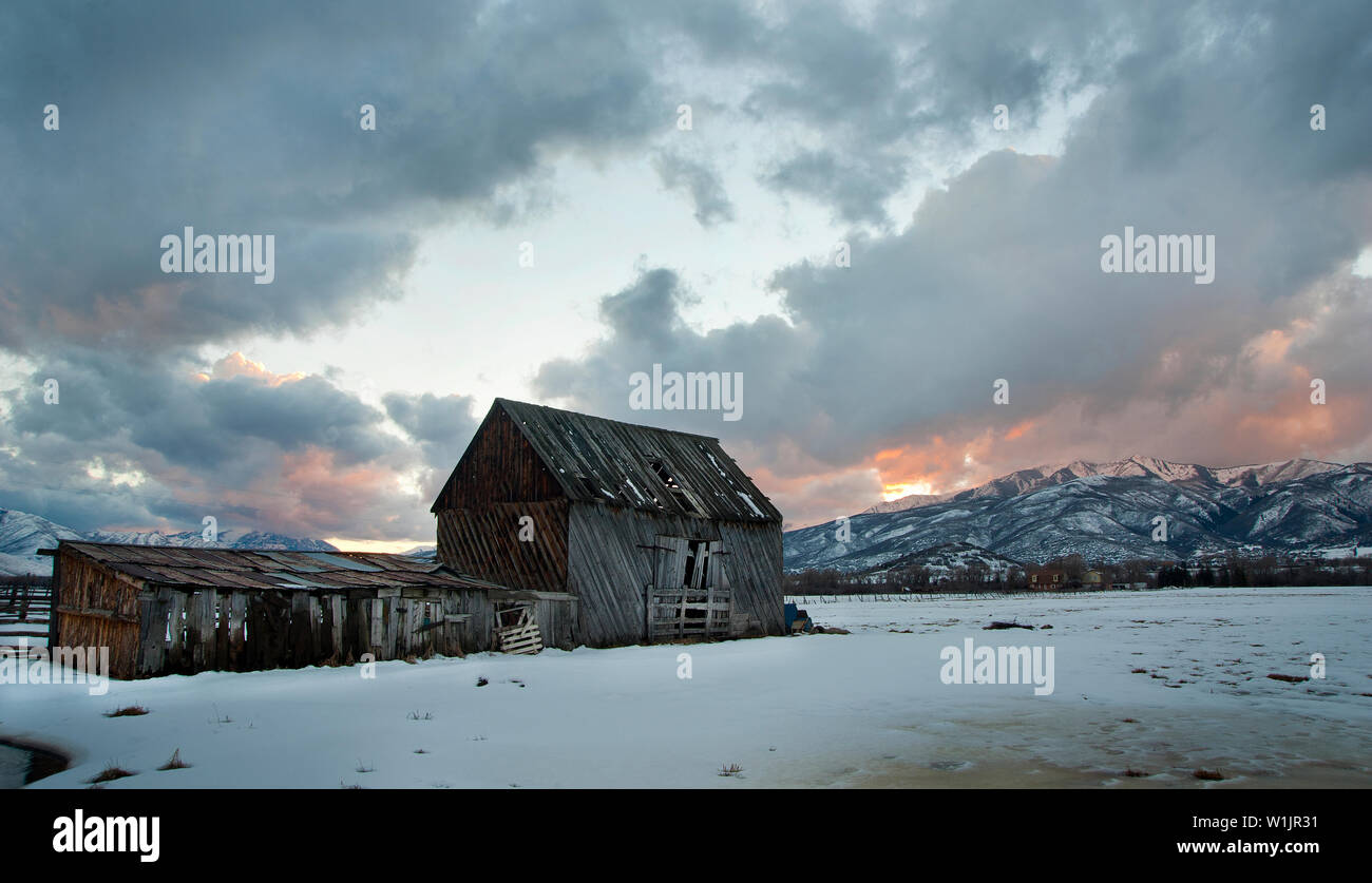 Storm clouds dance francically in the ski as the sun sets over the Wasatch Range on an old abandoned barn on a ranch near Midway, Utah. (c) 2015 Tom K Stock Photo