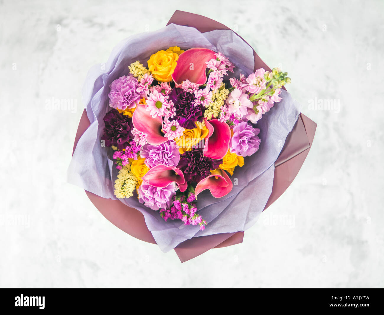 Lilac bouquet with arum lily or calla, roses, dianthus, chrysanthemum, limonium, matthiola. Focus on calla. Shallow DOF, copy space Stock Photo